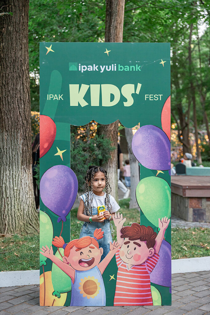 Девочка у фотозоны Ipak Yuli Kids Fest на детском экологическом фестивале